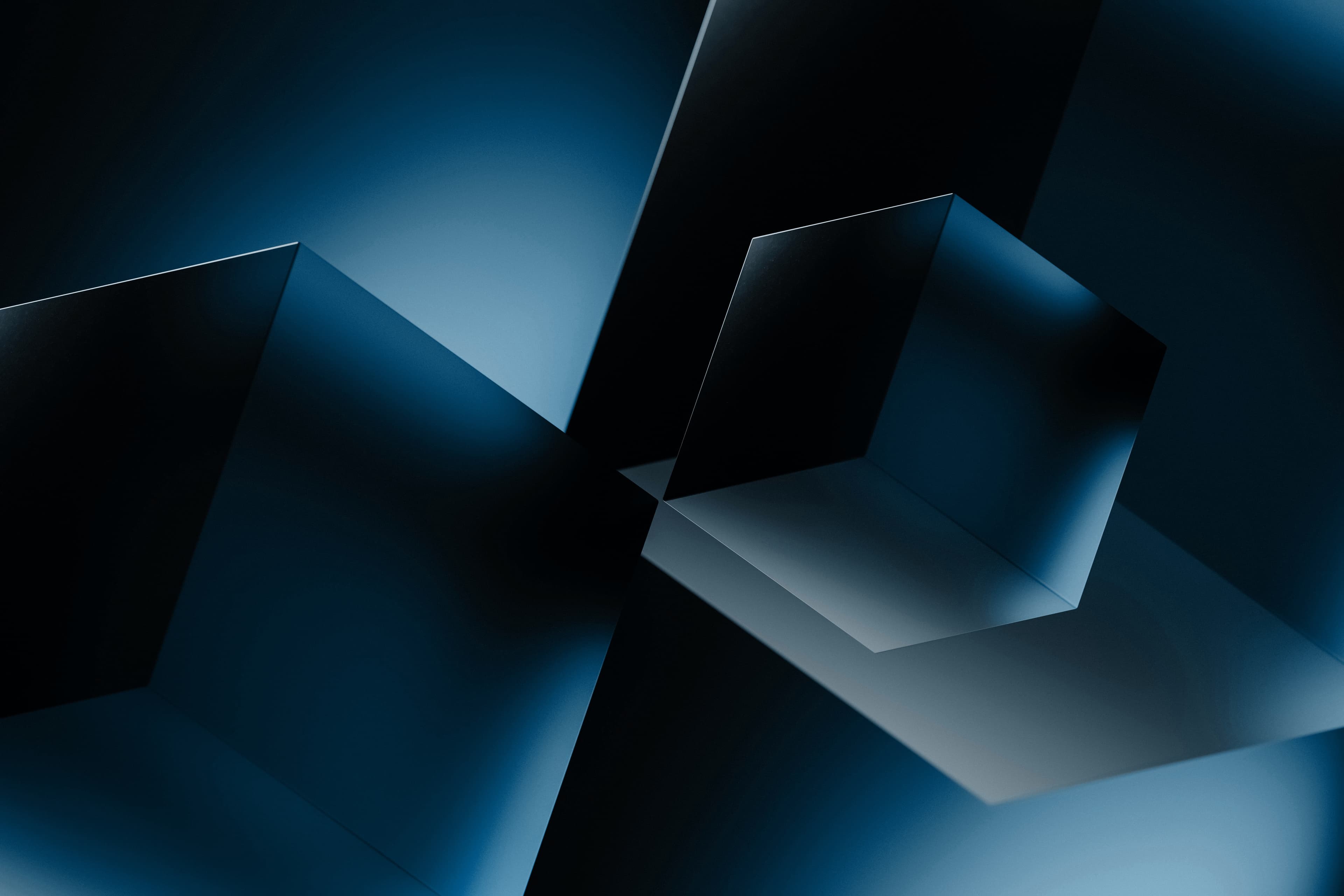 Abstract dark blue geometric composition featuring sharp-edged cubes and planes with dramatic lighting and shadows.